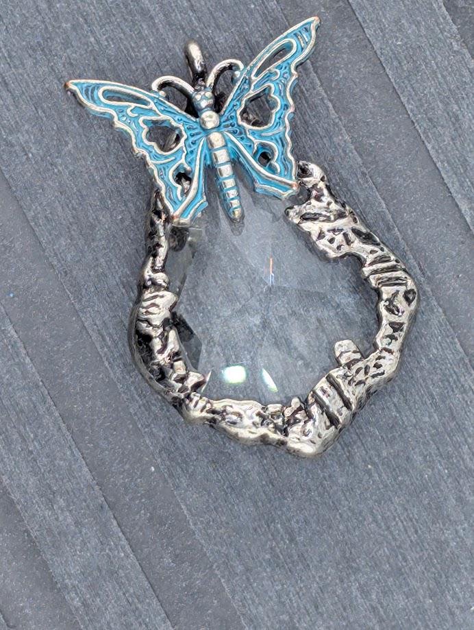 A keychain with a silver butterfly charm and a large black gemstone in the shape of a butterfly.