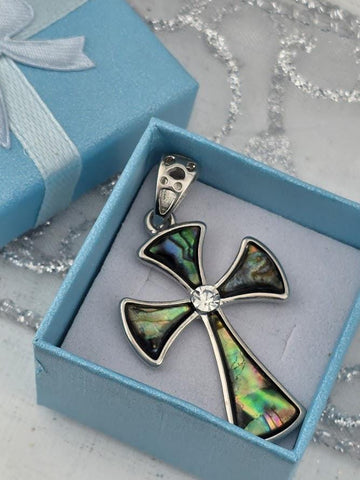 A silver cross pendant with colorful inlays is displayed in a blue gift box, with a silver clasp and a white ribbon bow.