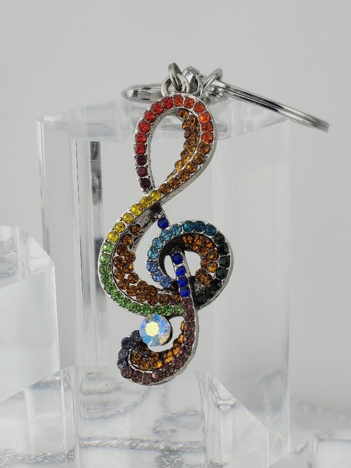 A colorful, sparkling keychain with a musical note design, featuring a combination of gemstones and rhinestones in various colors.