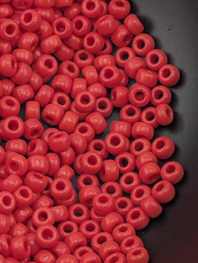 a close-up view of a pile of red plastic beads on a black surface.