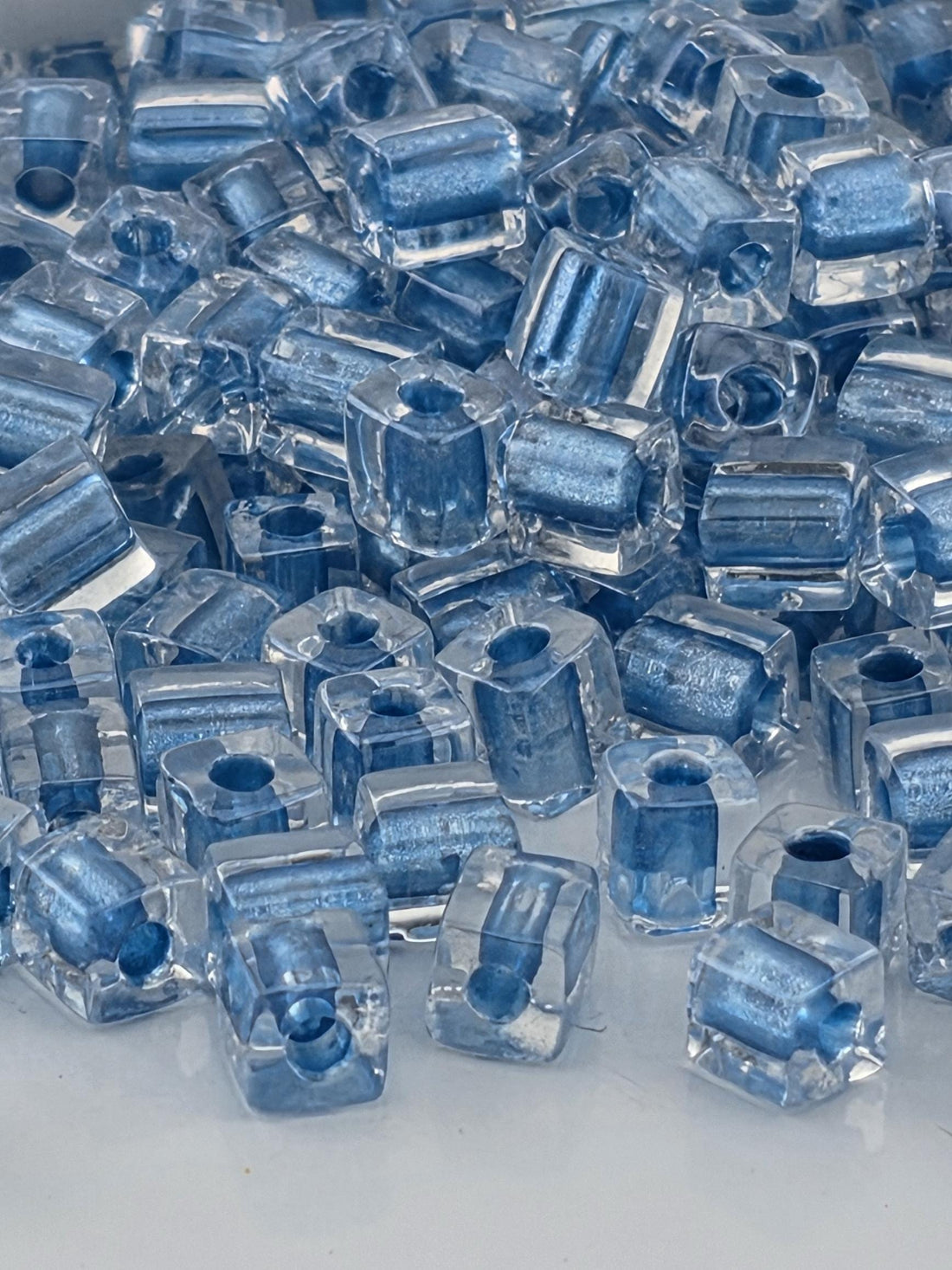 numerous clear glass beads scattered across a dark background.