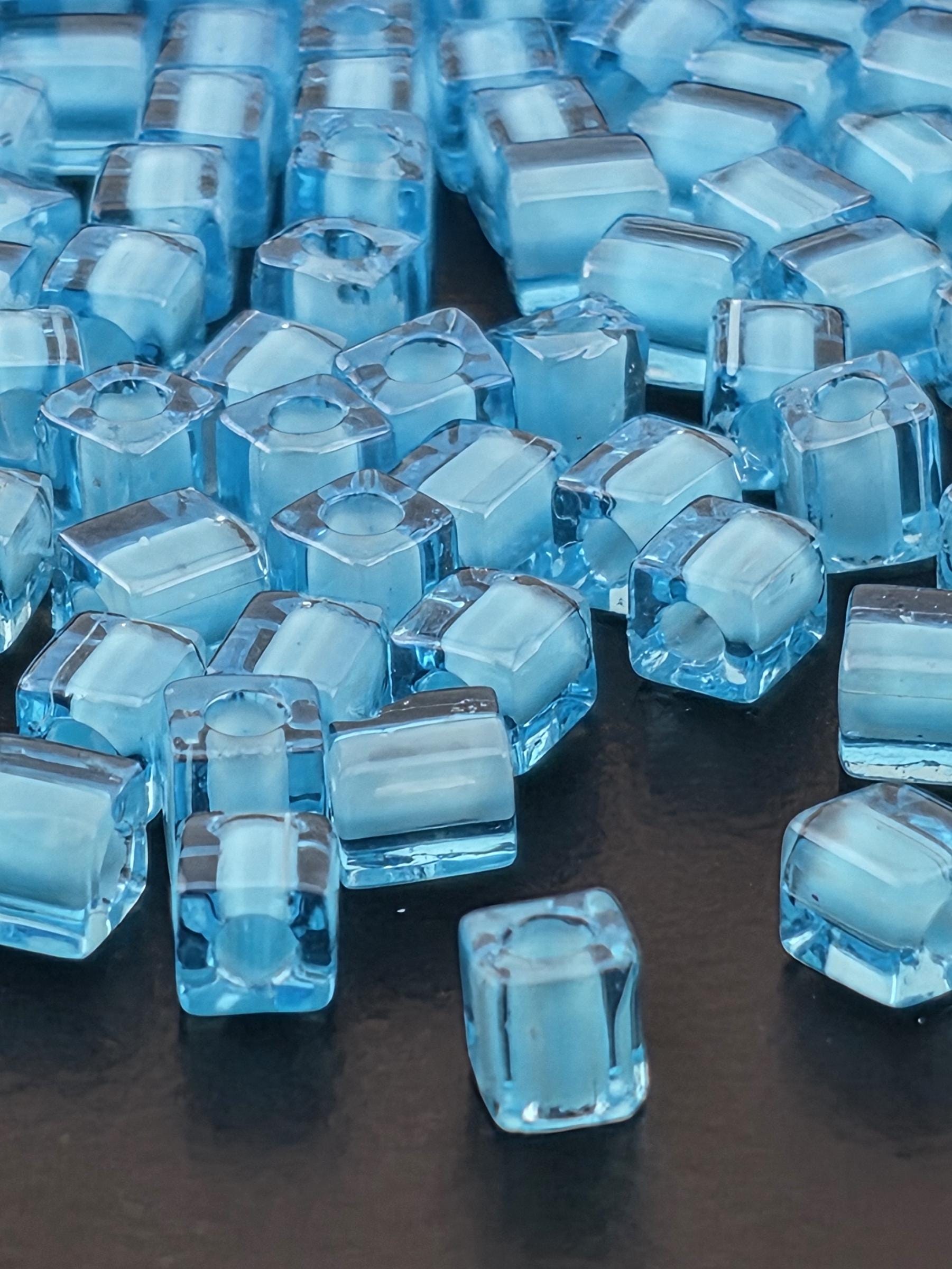 a close-up view of numerous clear, blue-tinted cubes or blocks arranged in a pattern.