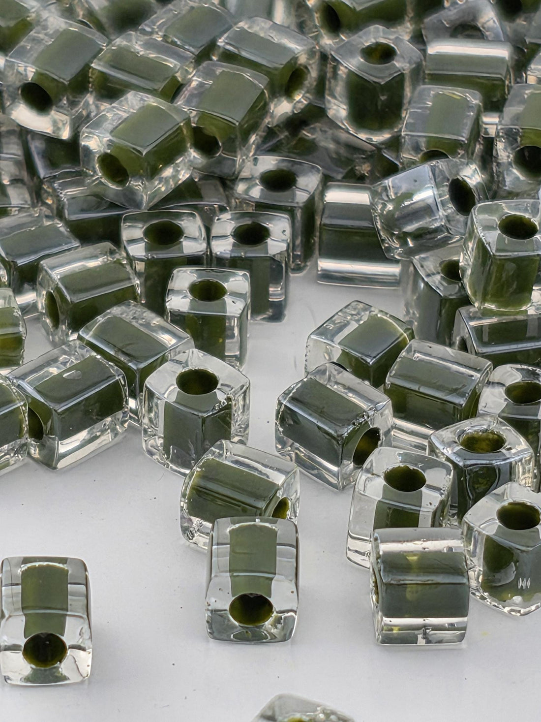 a collection of clear glass beads scattered across a surface, with some of the beads overlapping each other.