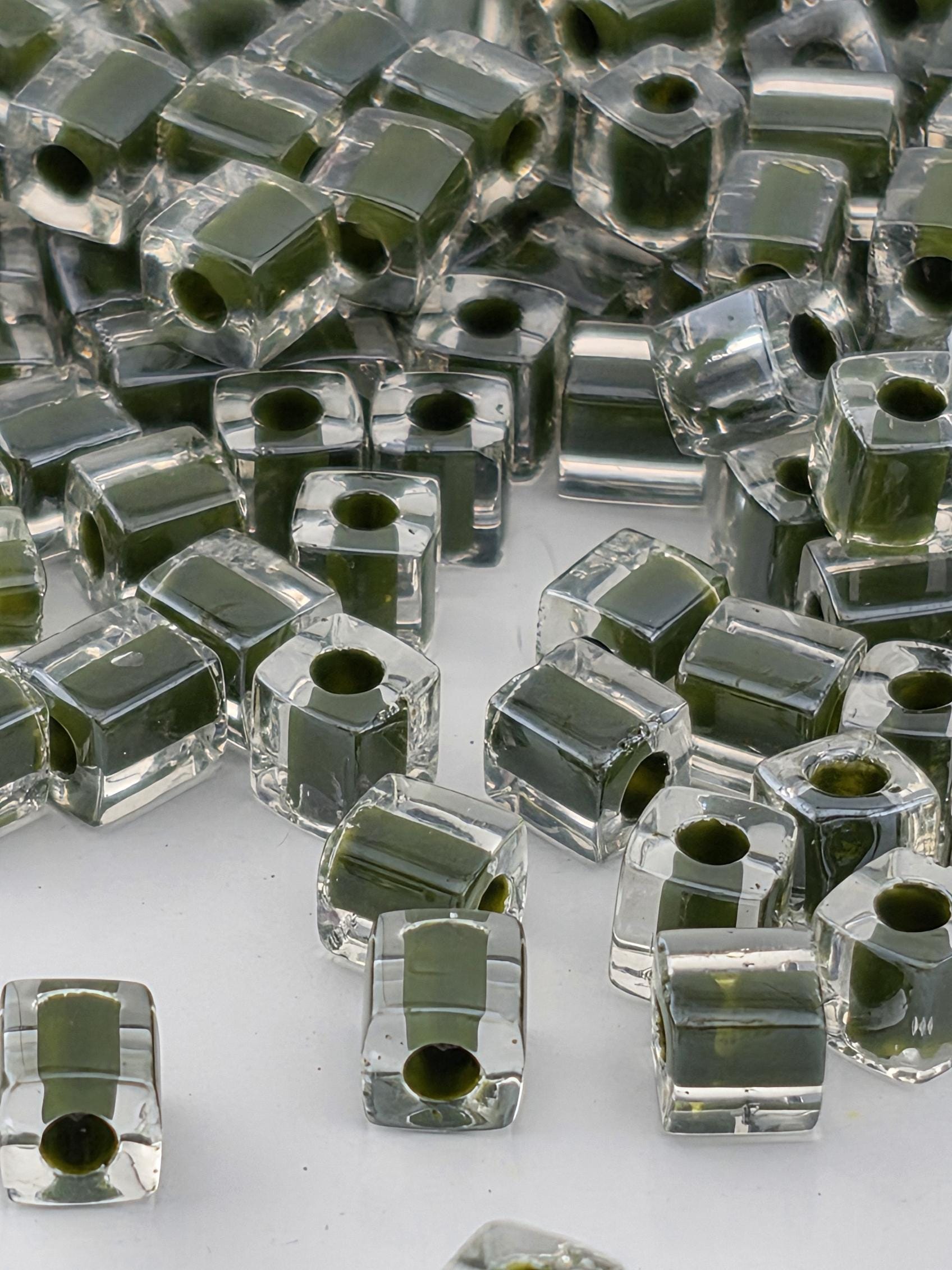 a collection of clear glass beads scattered across a surface, with some of the beads overlapping each other.