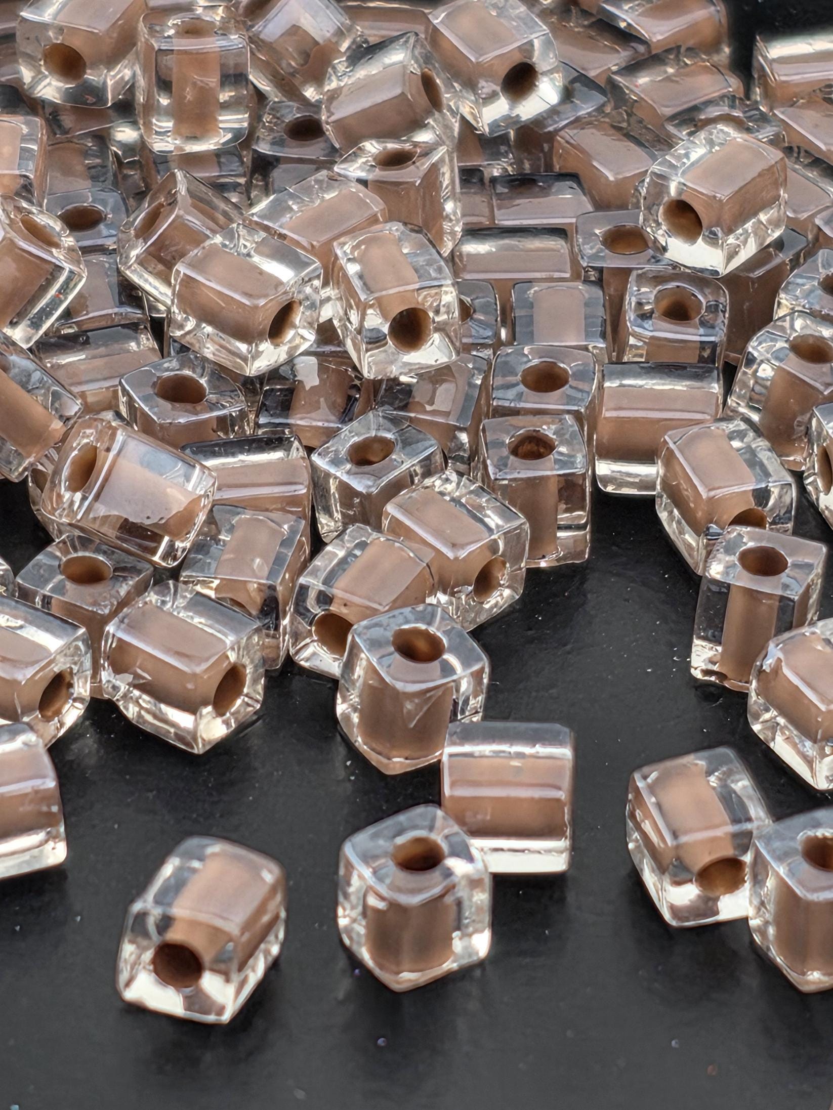 a collection of clear glass beads scattered on a dark surface.