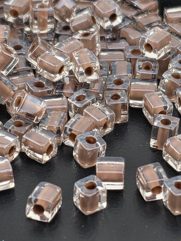 a collection of clear glass beads scattered on a dark surface.