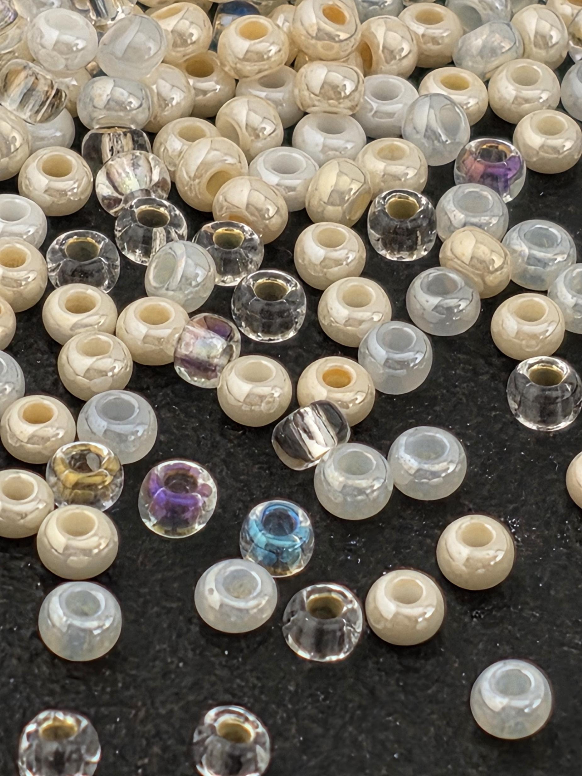 a collection of various colored glass beads scattered on a dark surface.