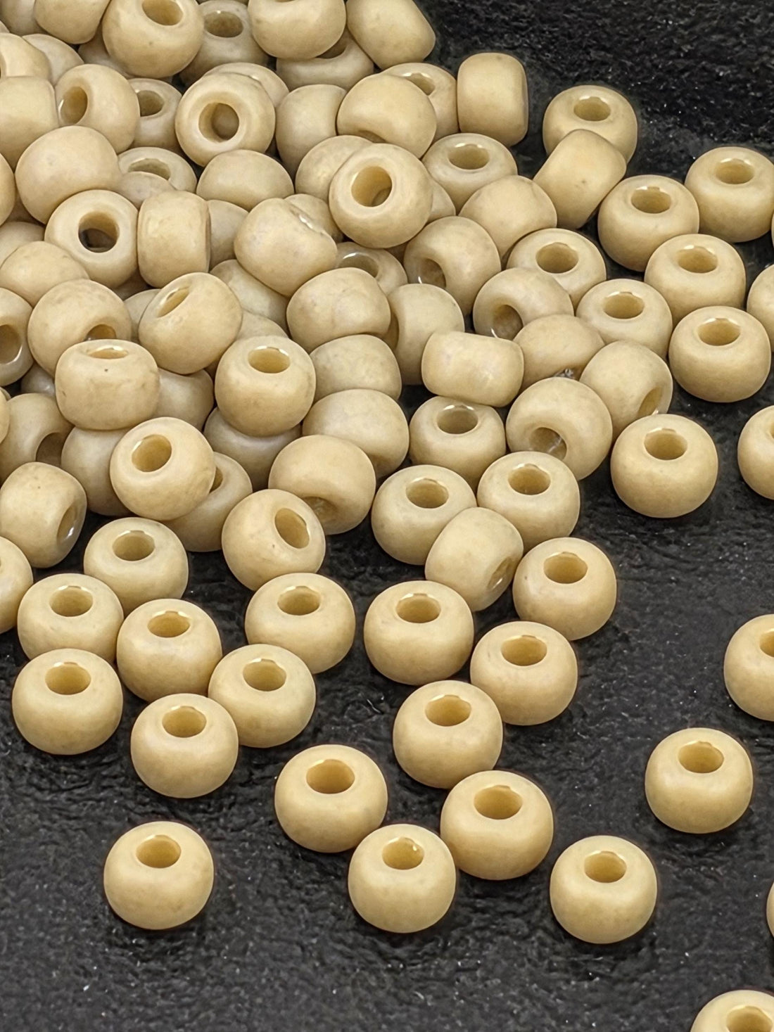 a collection of small, round beads scattered on a dark surface.