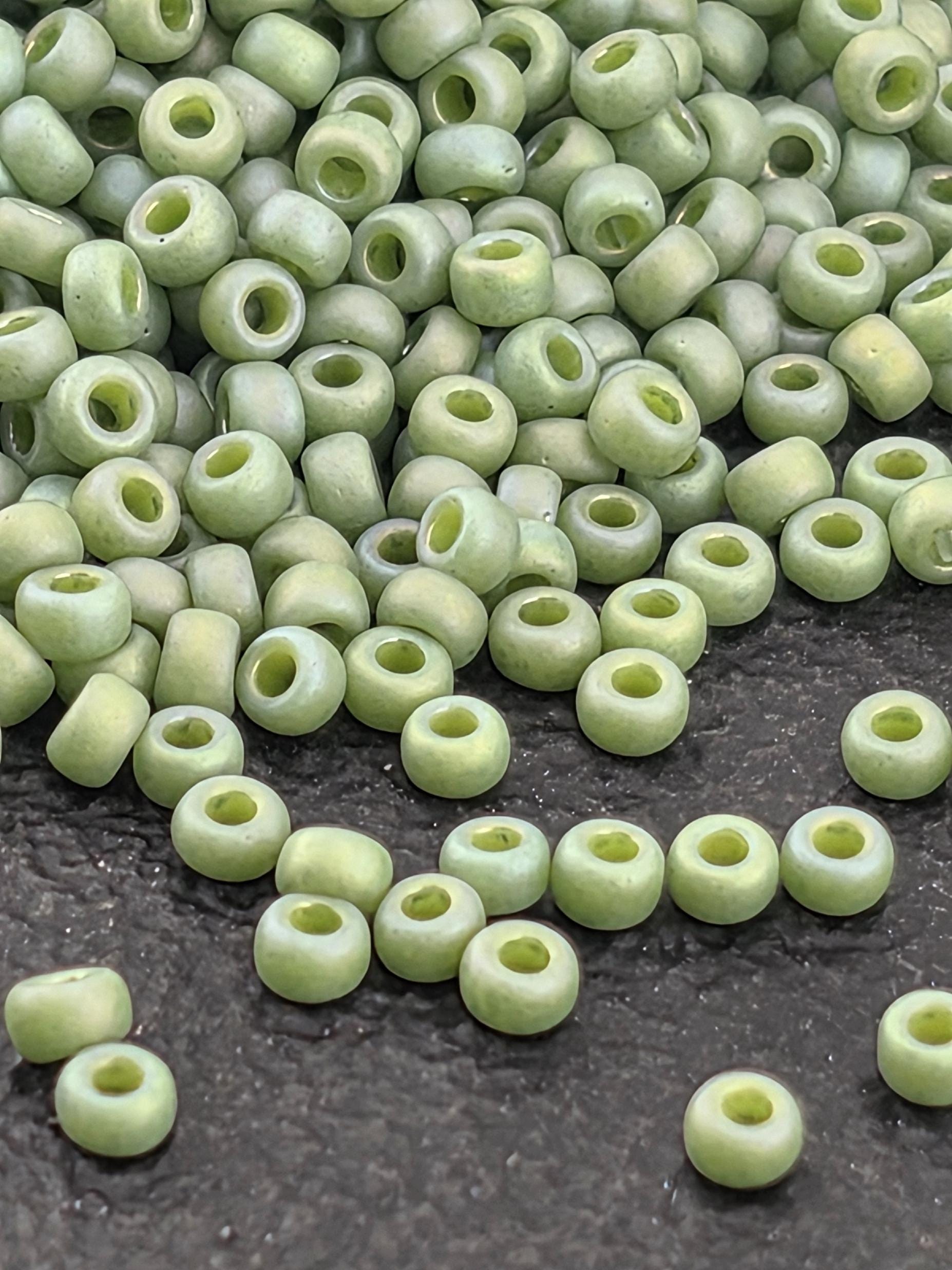 a collection of small, round green beads scattered on a dark surface.