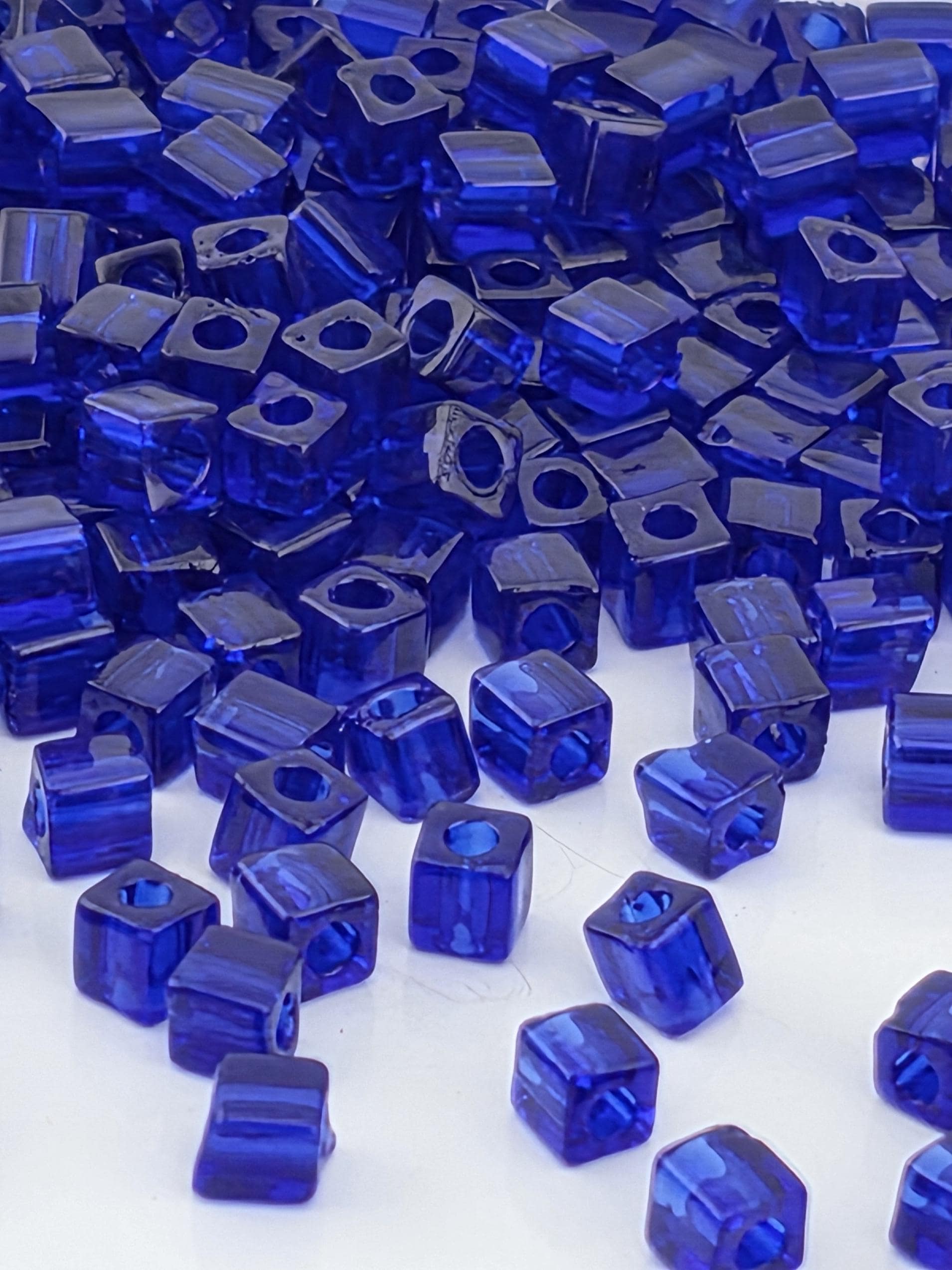 numerous blue glass beads scattered across a surface, creating a visually striking and vibrant display.