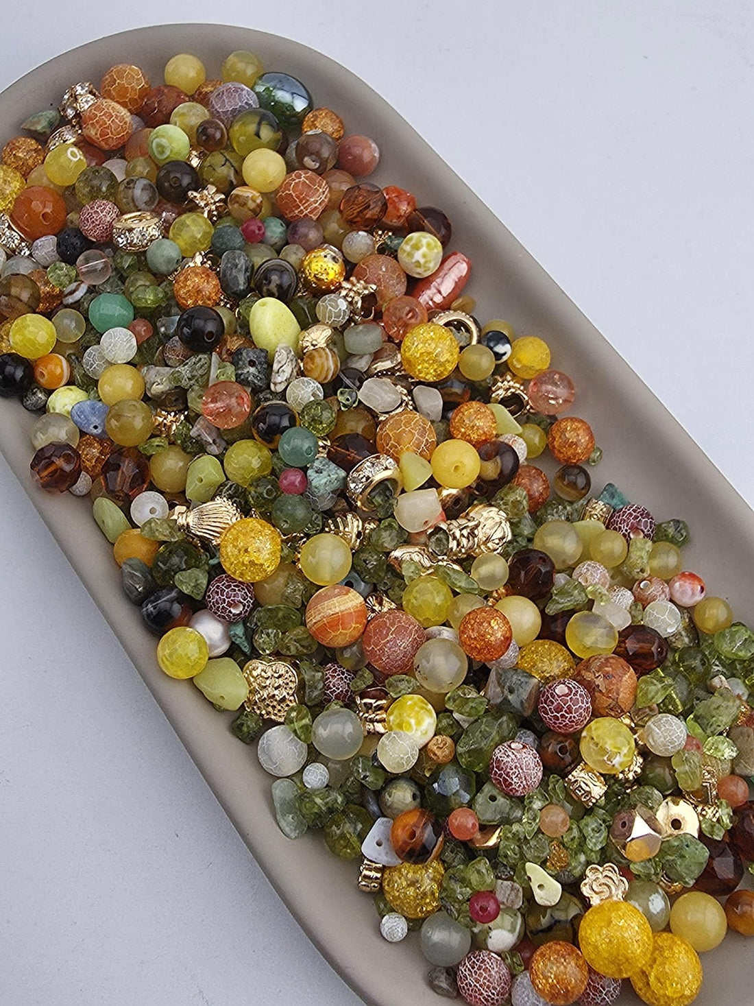 A large collection of colorful beads and gemstones arranged on a white surface.