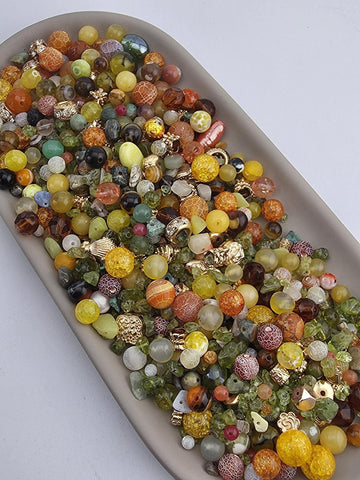 A large collection of colorful beads and gemstones arranged on a white surface.