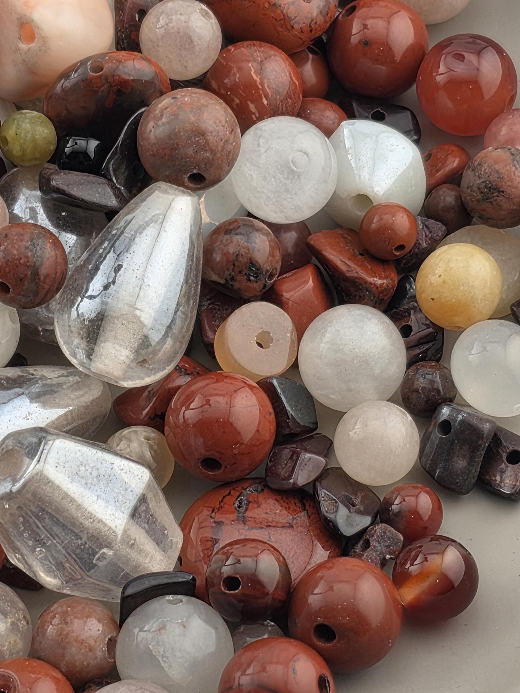 a variety of colorful beads and stones, including clear and colored beads, arranged together.