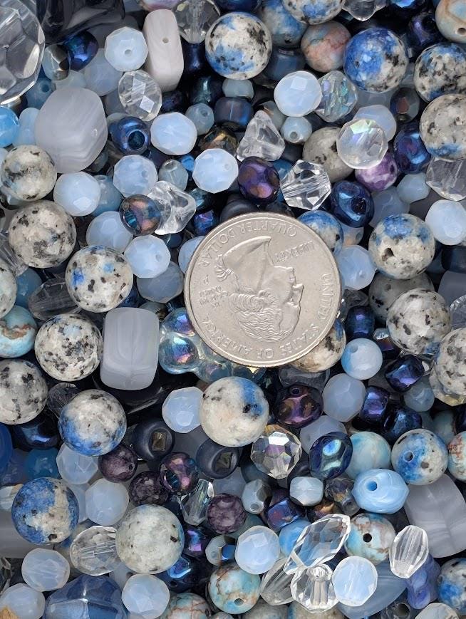 The image is a collage of various beads and gemstones, including clear and blue beads, as well as a silver coin.