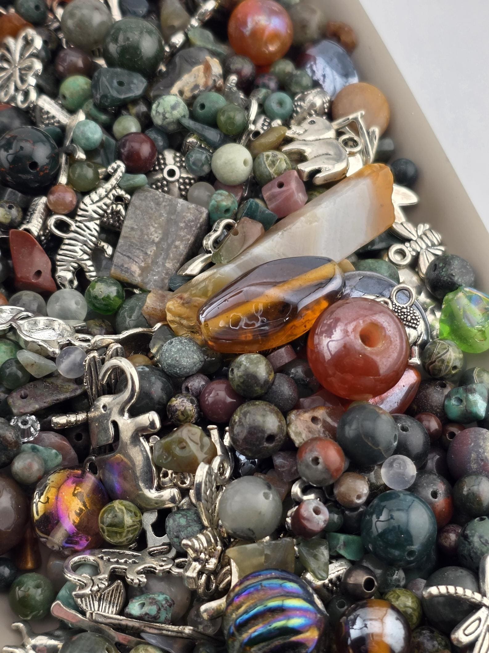 A close-up image of a variety of colorful beads, charms, and other small objects scattered together.
