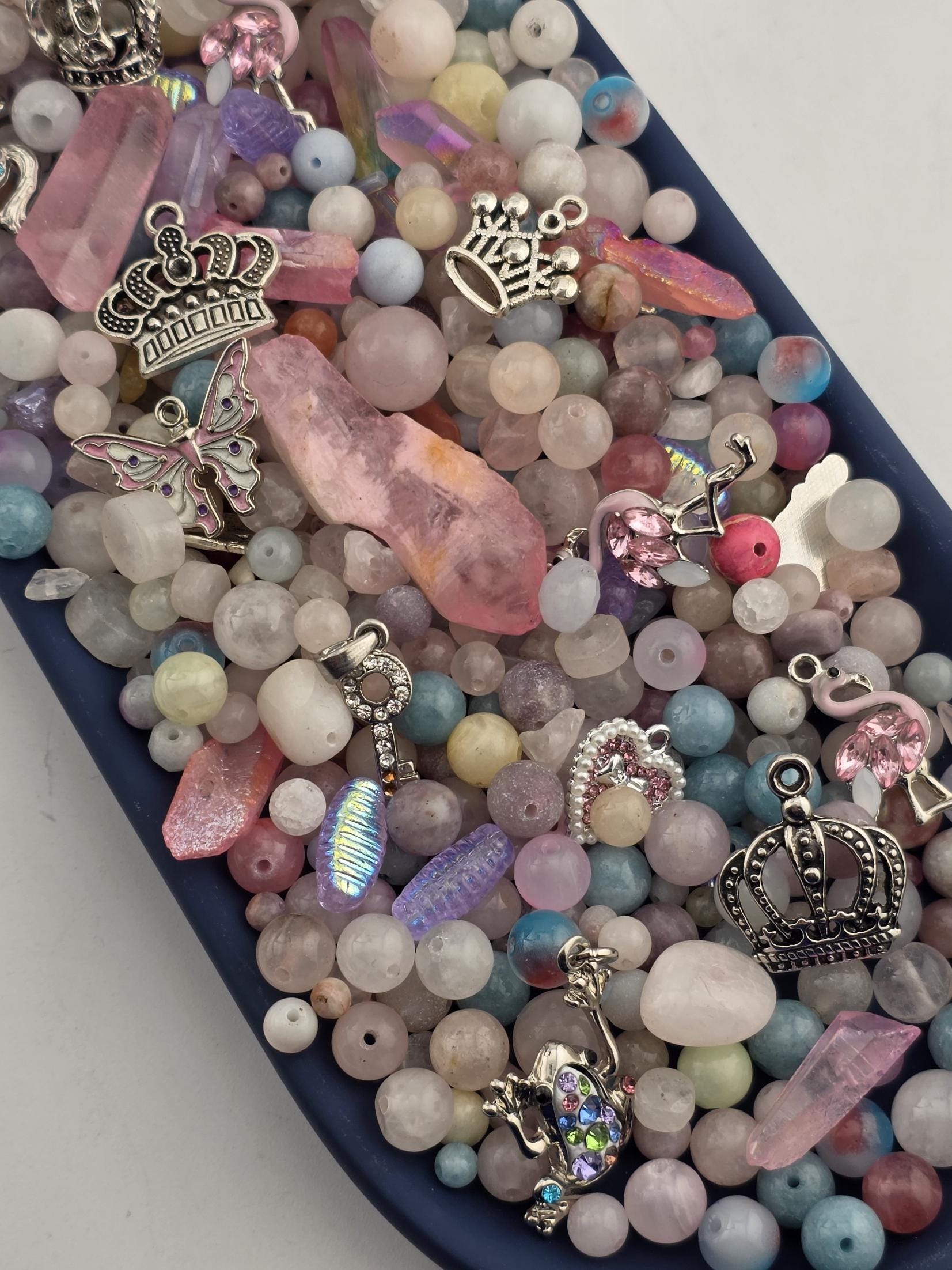A collection of various beads, charms, and trinkets arranged on a surface.