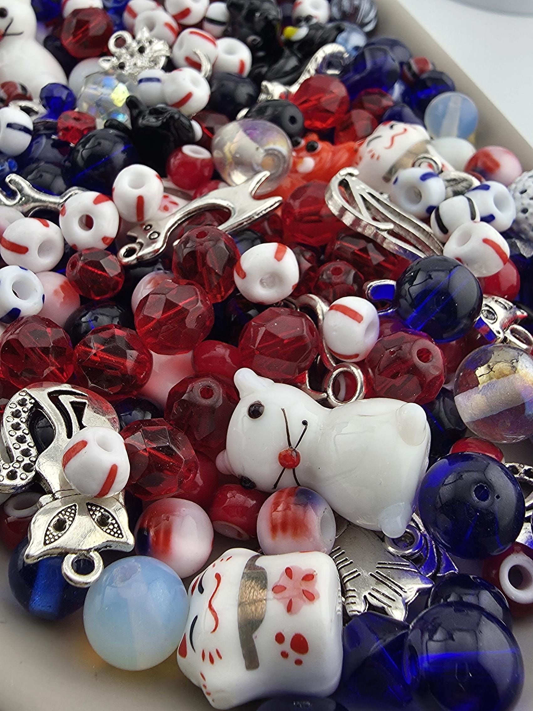A colorful assortment of beads, charms, and other decorative items, including a small white teddy bear, are scattered across the image.