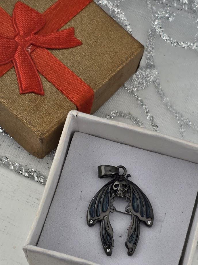 a pendant in the shape of a butterfly, displayed in a white box with a red ribbon.