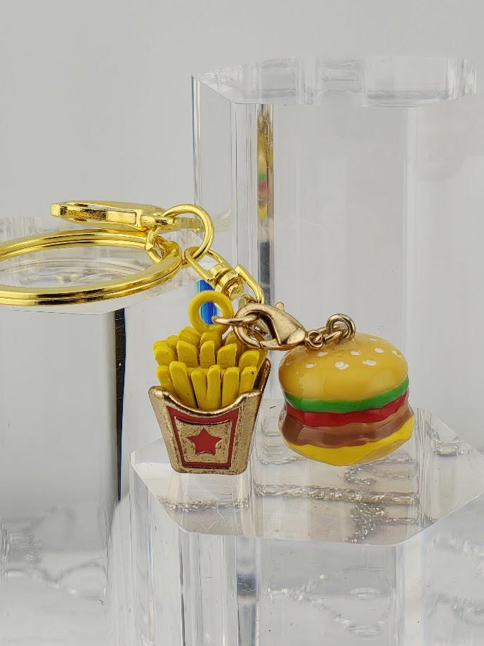 A keychain featuring a miniature hamburger and french fries, with a star-shaped container holding the french fries.