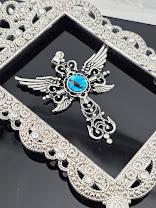 A silver-toned pendant with a blue eye design, featuring intricate wing-like patterns and a central eye-shaped element.