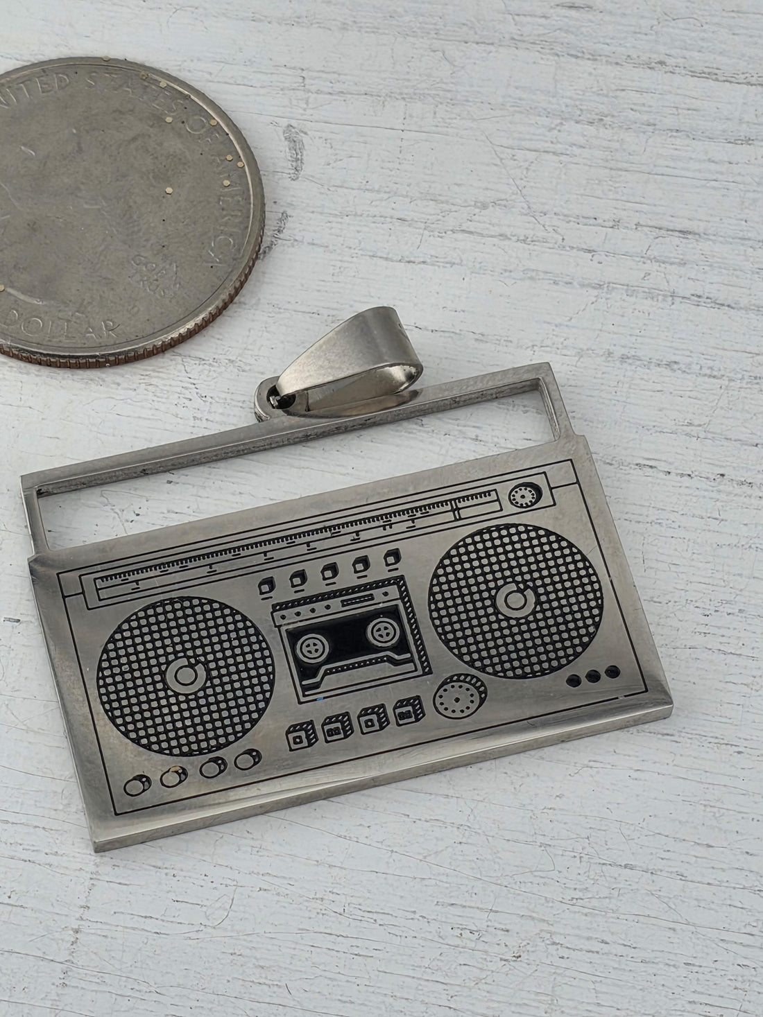 a small, metallic object resembling a boombox or radio, placed on top of a brown gift box with a red ribbon.
