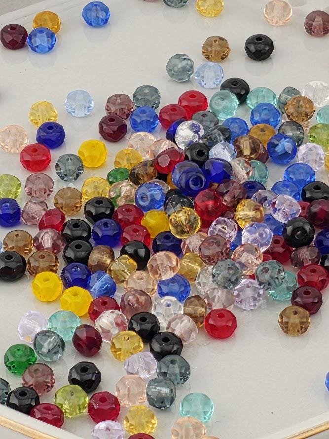 a collection of colorful glass beads scattered on a white surface.