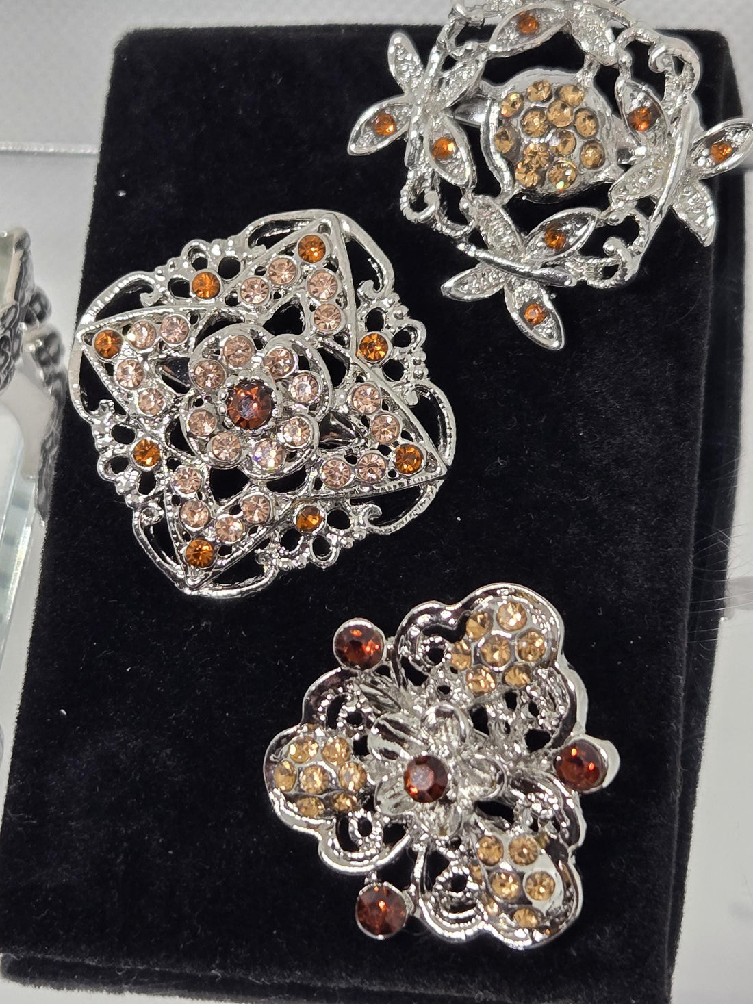 a collection of ornate, metallic brooches with intricate designs and sparkling gemstones.