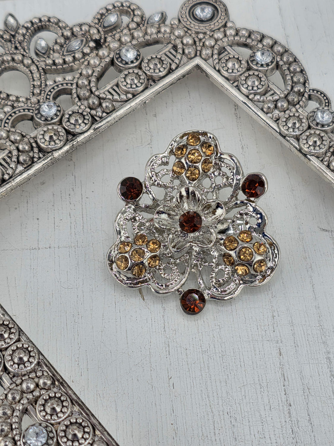 a collection of ornate, metallic brooches with intricate designs and sparkling gemstones.