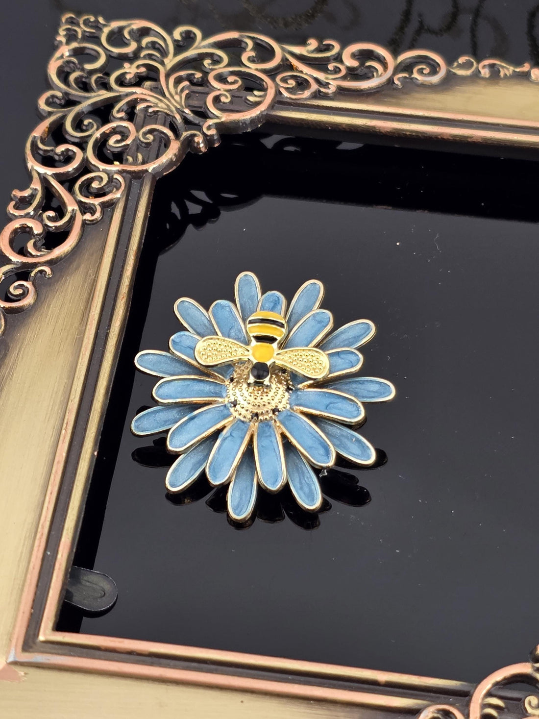 A decorative gold frame with a blue flower design on its surface.