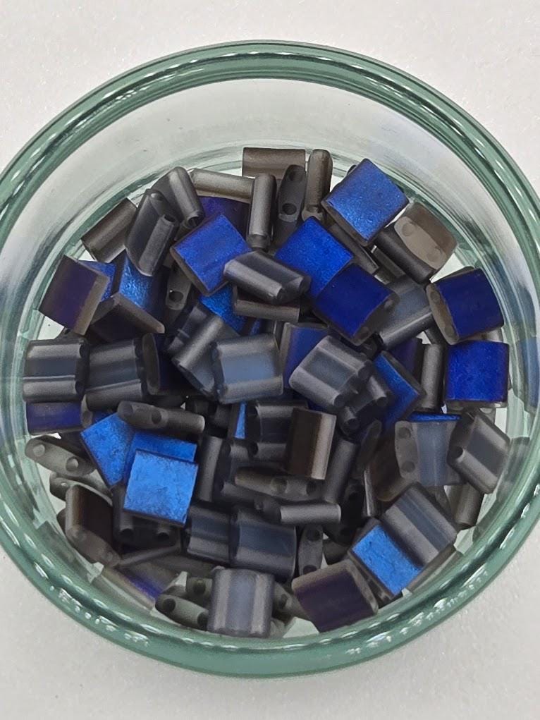 A glass bowl filled with small blue and gray beads or objects.