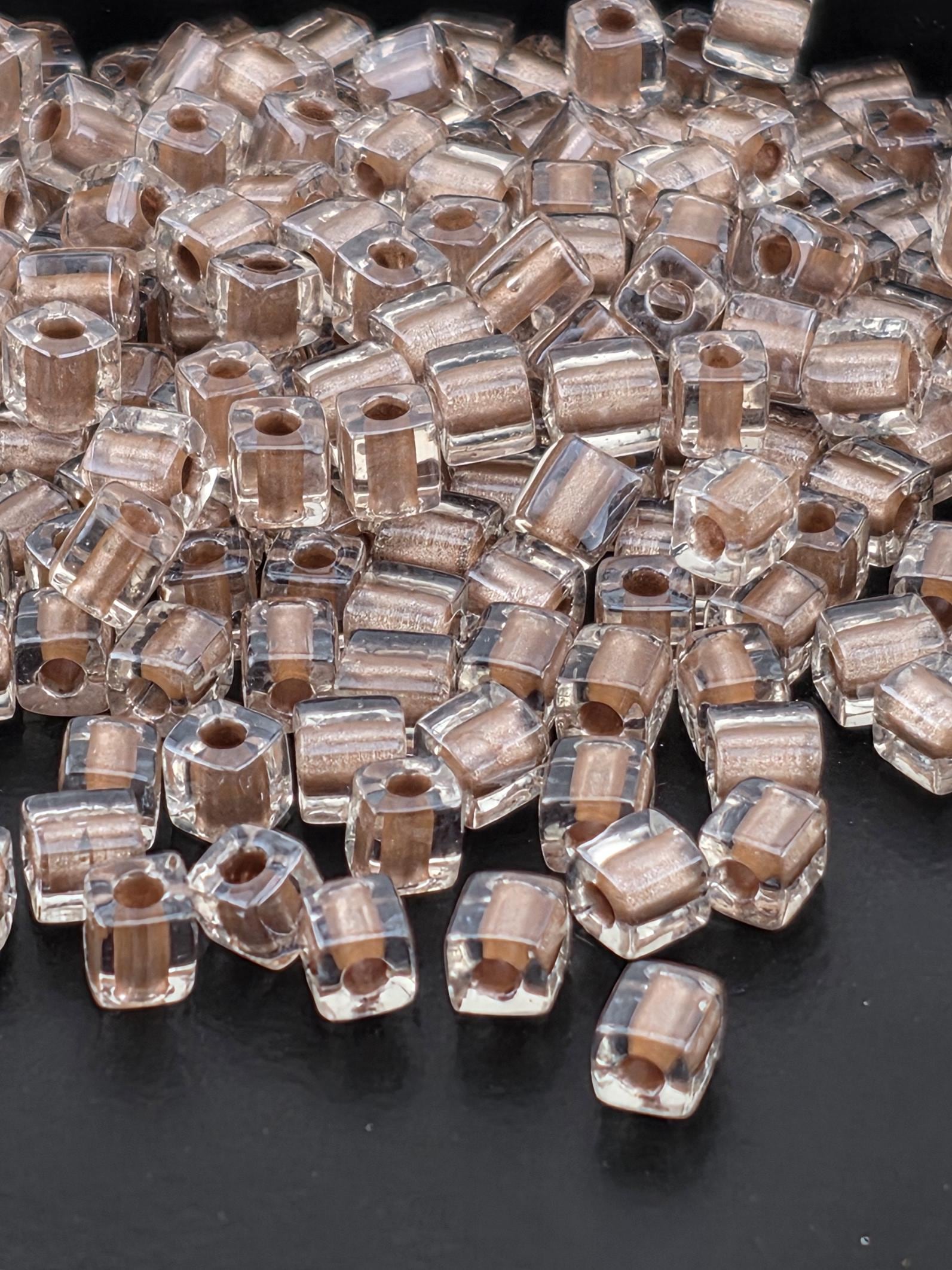 a close-up view of numerous clear glass beads scattered on a dark background.