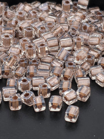 a close-up view of numerous clear glass beads scattered on a dark background.