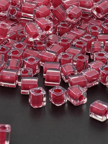numerous clear, transparent, and red-colored cubes or blocks arranged in a visually striking manner.
