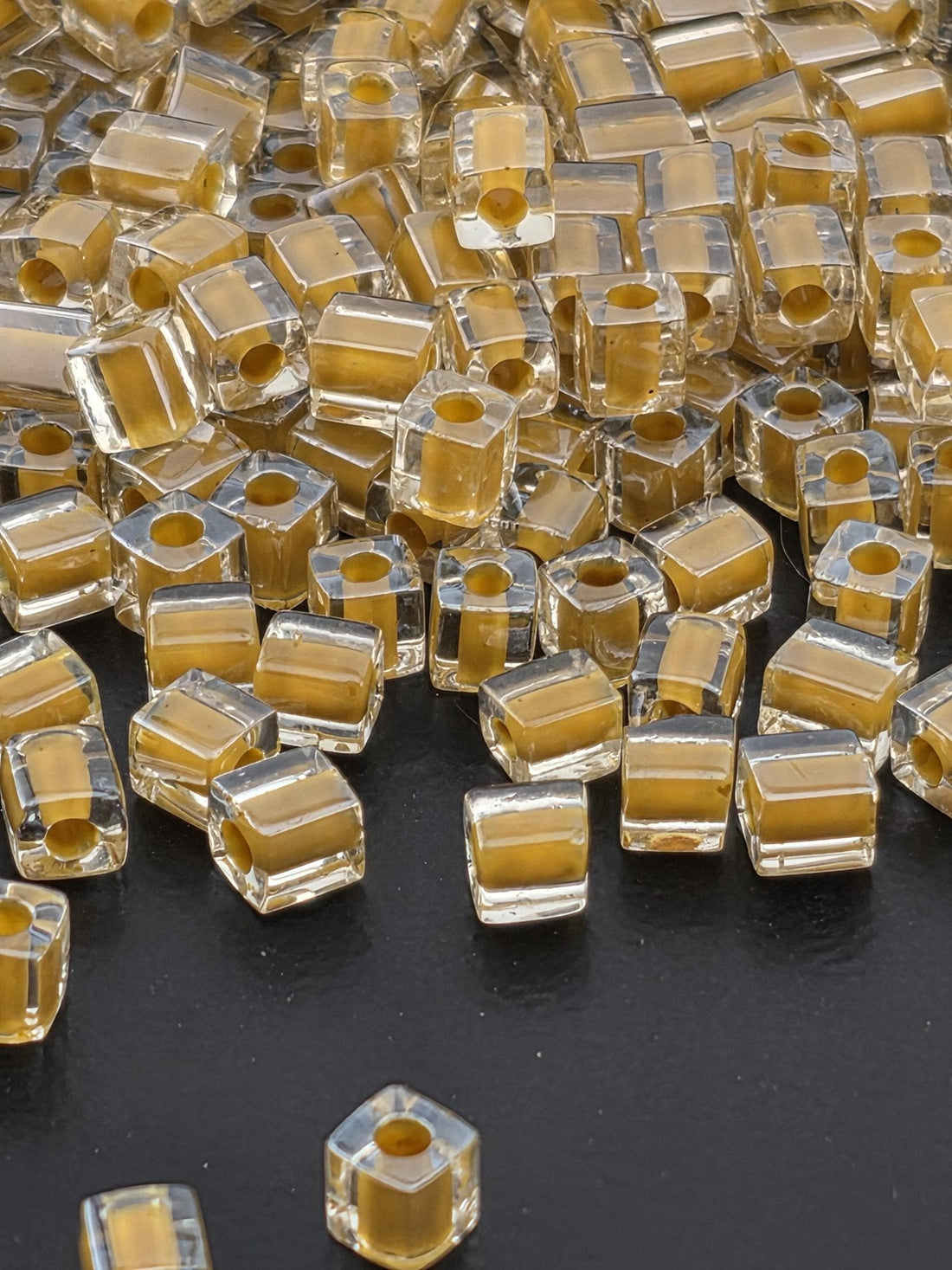 a collection of clear glass beads scattered on a dark background.