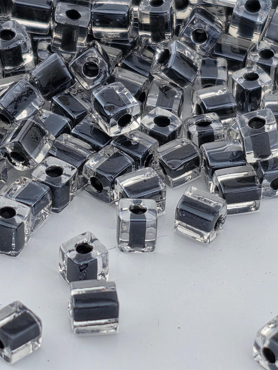 a collection of clear glass beads scattered across a white surface.