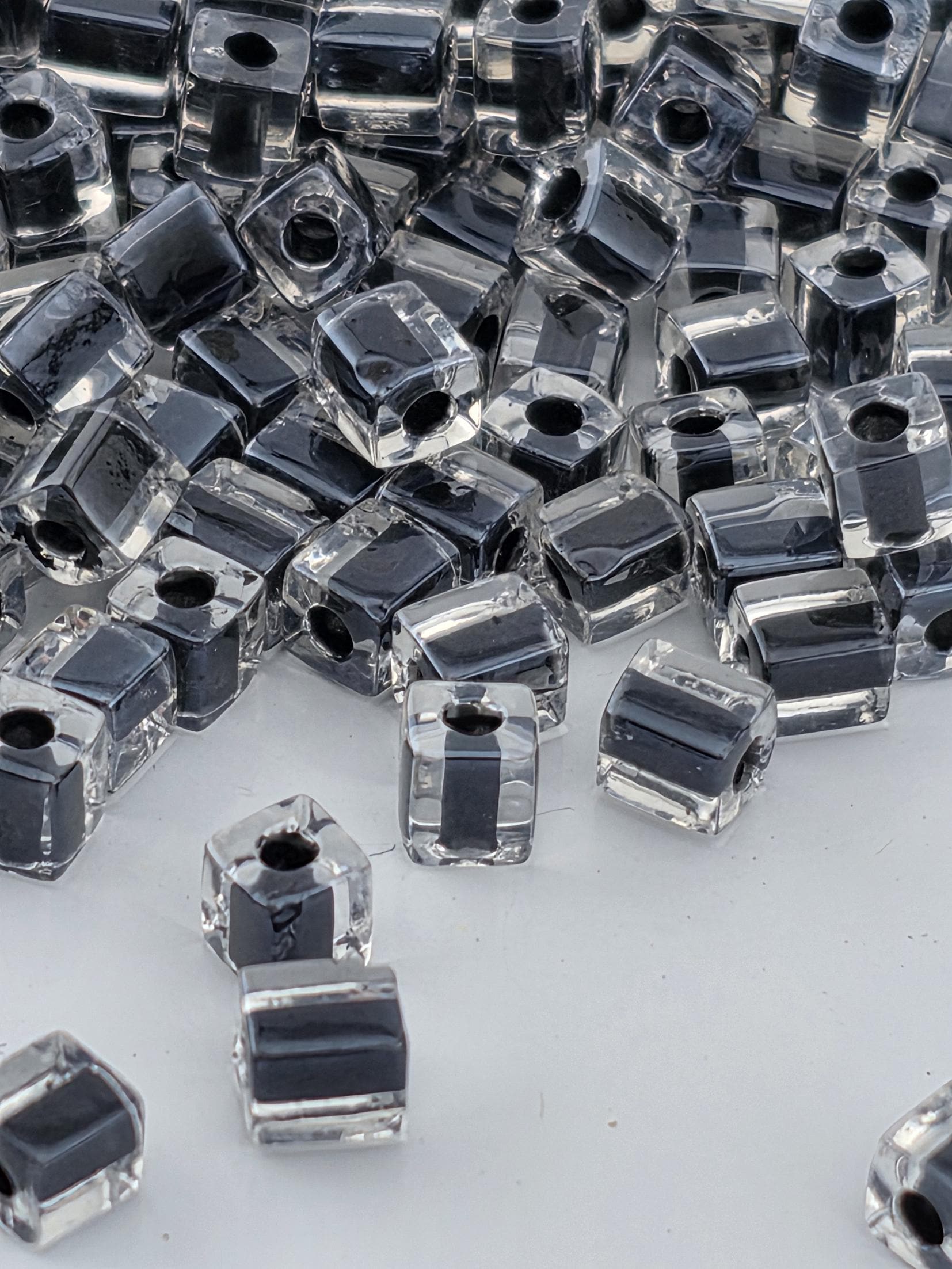 a collection of clear glass beads scattered across a white surface.