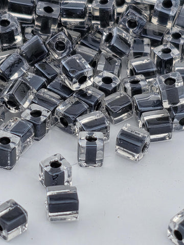 a collection of clear glass beads scattered across a white surface.