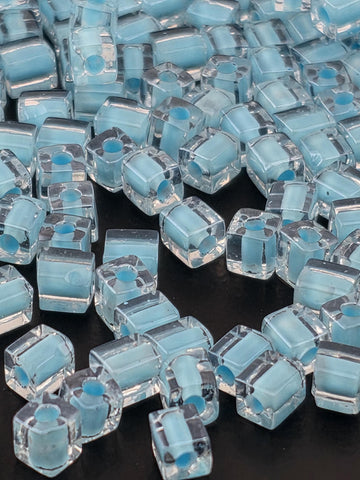 numerous small, clear glass beads scattered across a dark background.