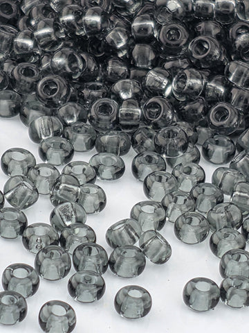a collection of small, clear beads in various shades of gray, scattered across a white background.