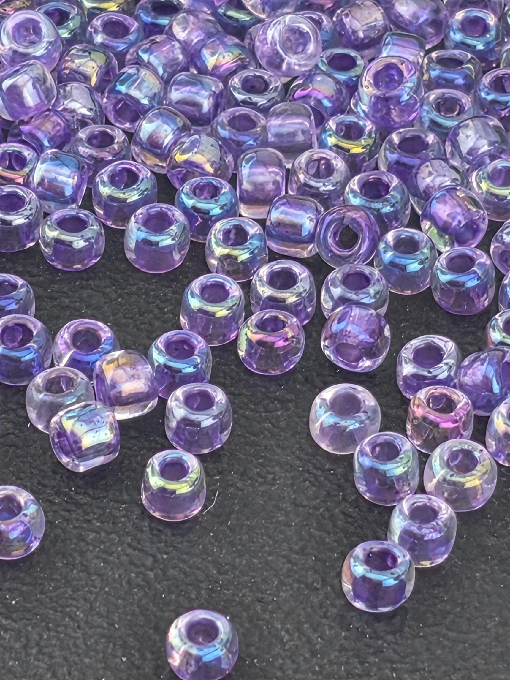 a collection of small, clear beads scattered on a dark surface.