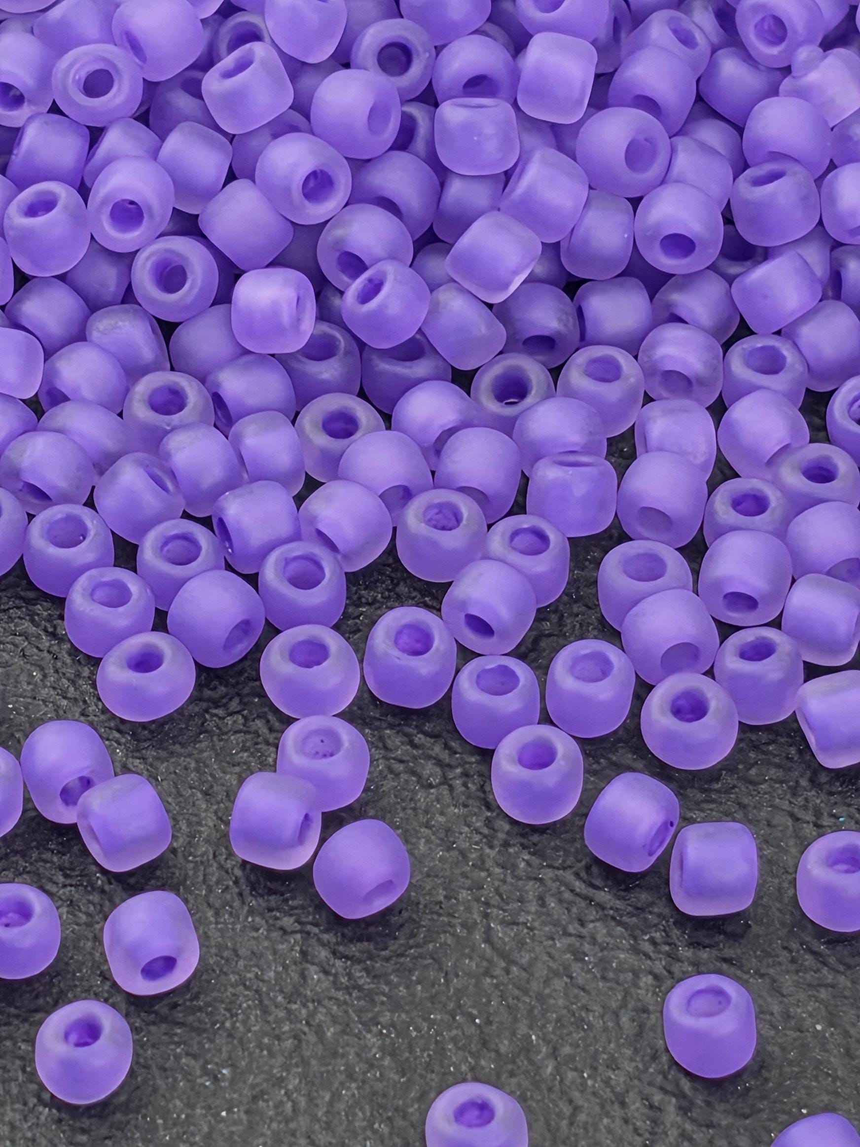 a close-up view of numerous purple beads scattered on a dark surface.