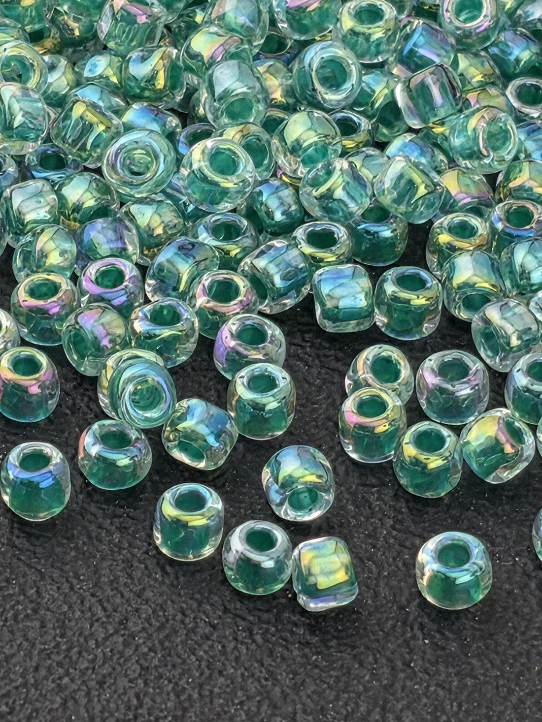 a collection of clear glass beads scattered on a dark surface.