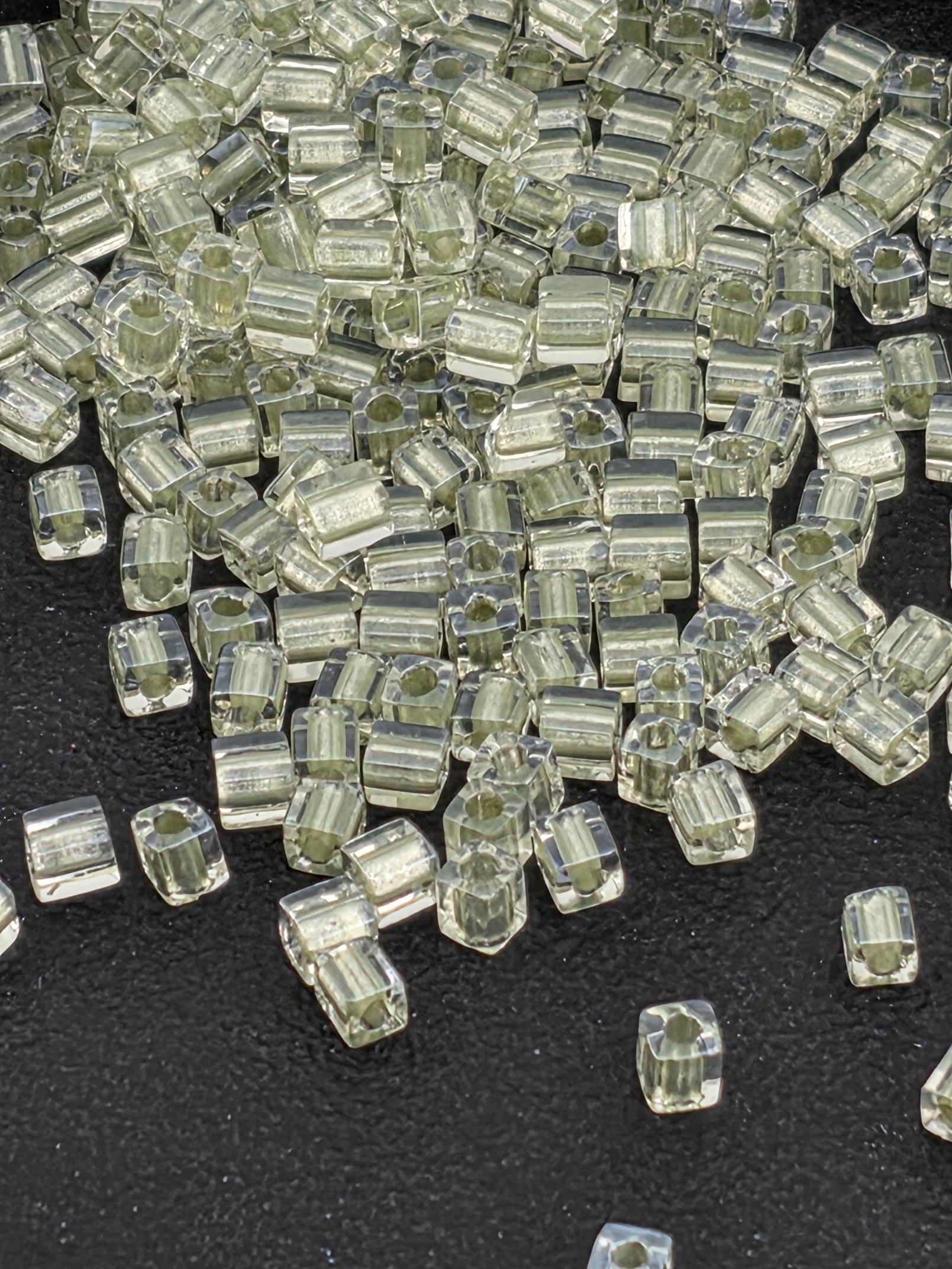 a collection of small, clear, and transparent objects scattered on a dark surface.