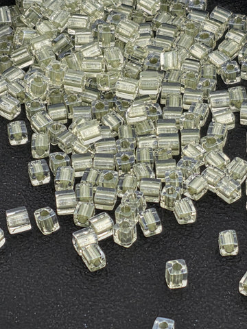 a collection of small, clear, and transparent objects scattered on a dark surface.