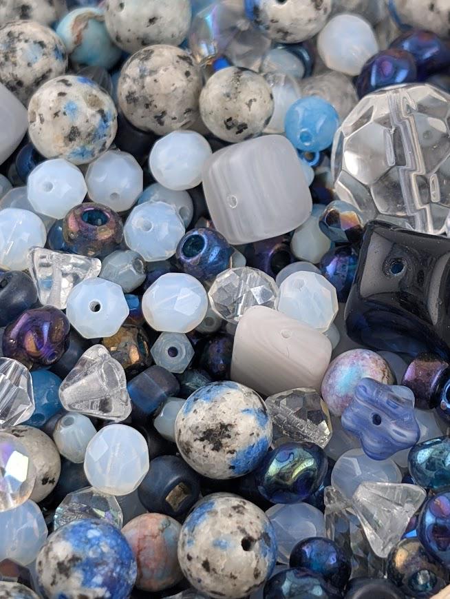 The image is a close-up of various beads and glass beads, showcasing a diverse collection of colors and shapes.