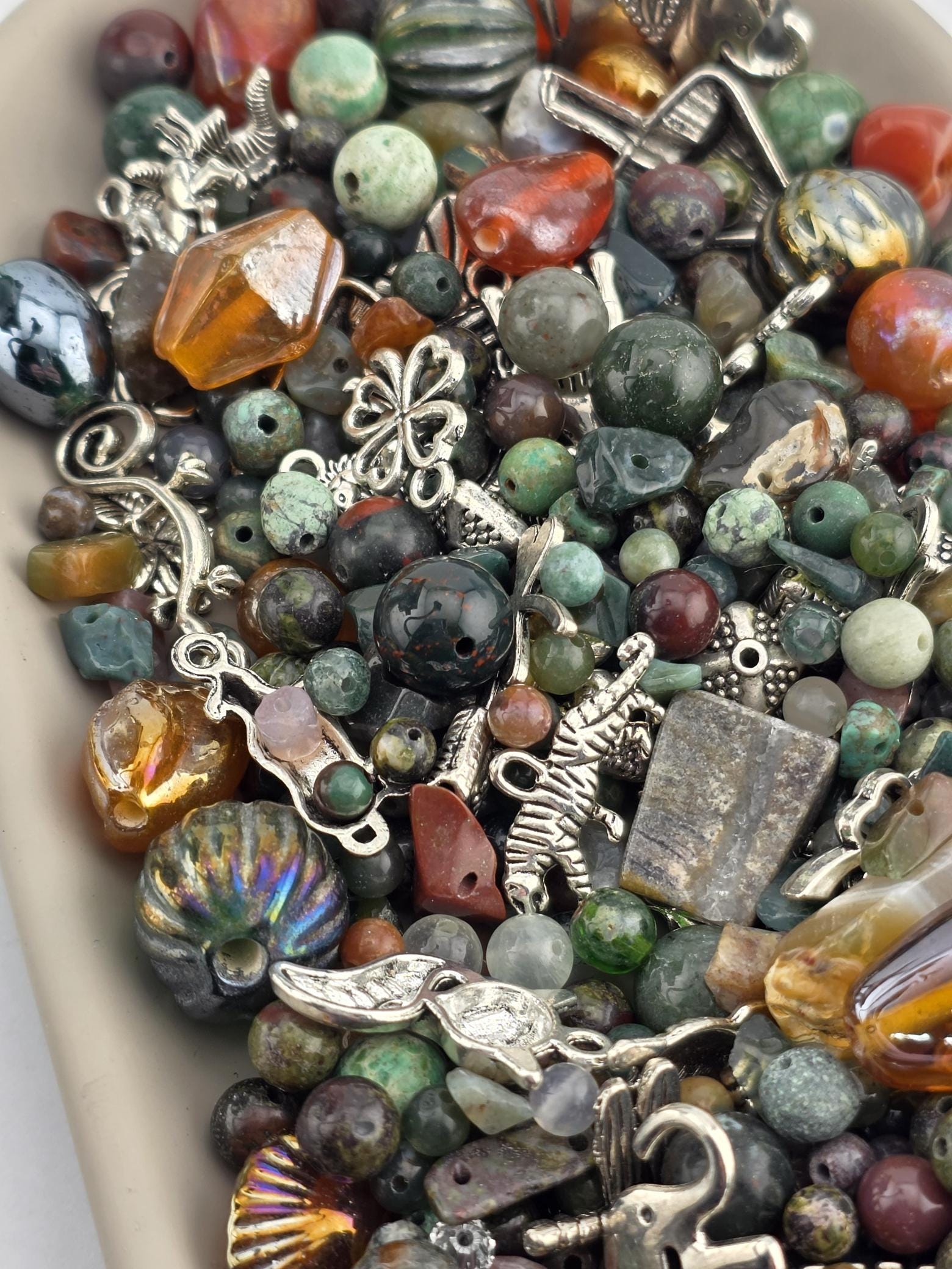 A close-up image of a variety of colorful beads, charms, and other decorative items arranged on a surface.