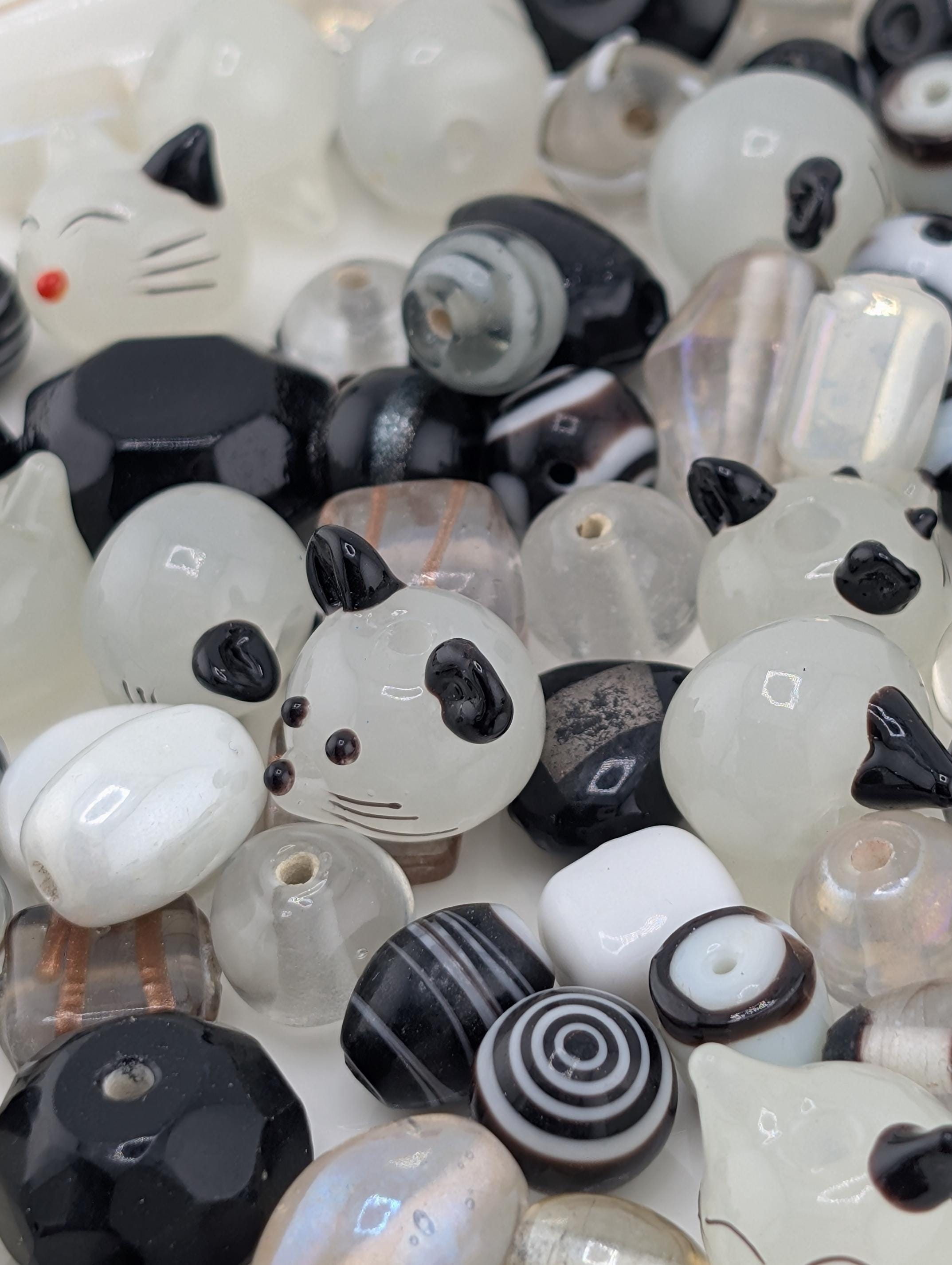 a variety of colorful beads, including black, white, and multicolored beads, arranged in a visually appealing manner.