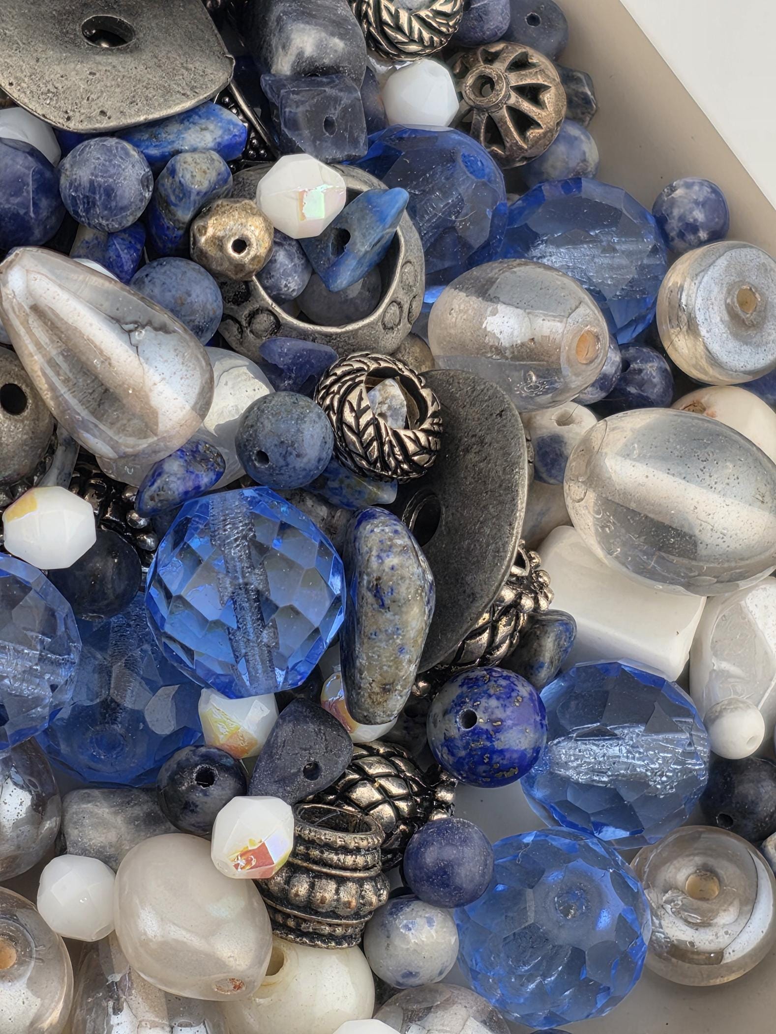 a variety of colorful beads and glass beads, including clear, blue, and silver beads, as well as metal beads and glass beads.
