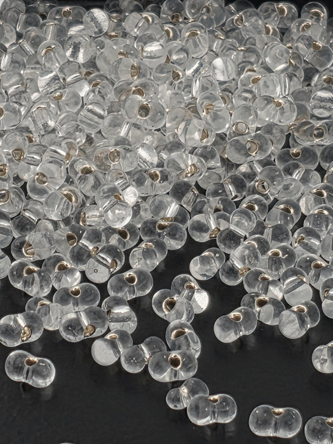 a close-up view of numerous clear glass beads scattered on a surface.