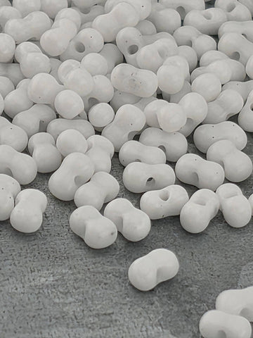 numerous white, spherical objects scattered across a textured gray surface.